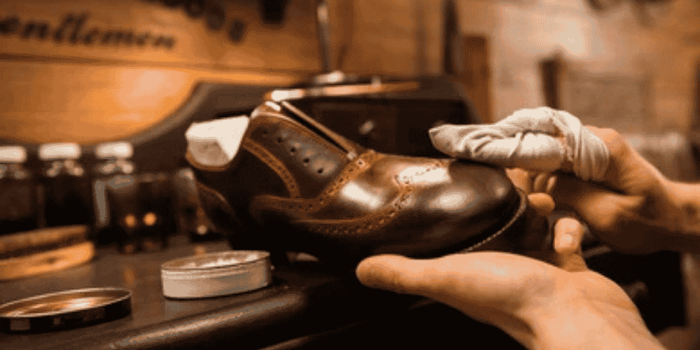 a man buffing leather shoes with dubbin to get shine