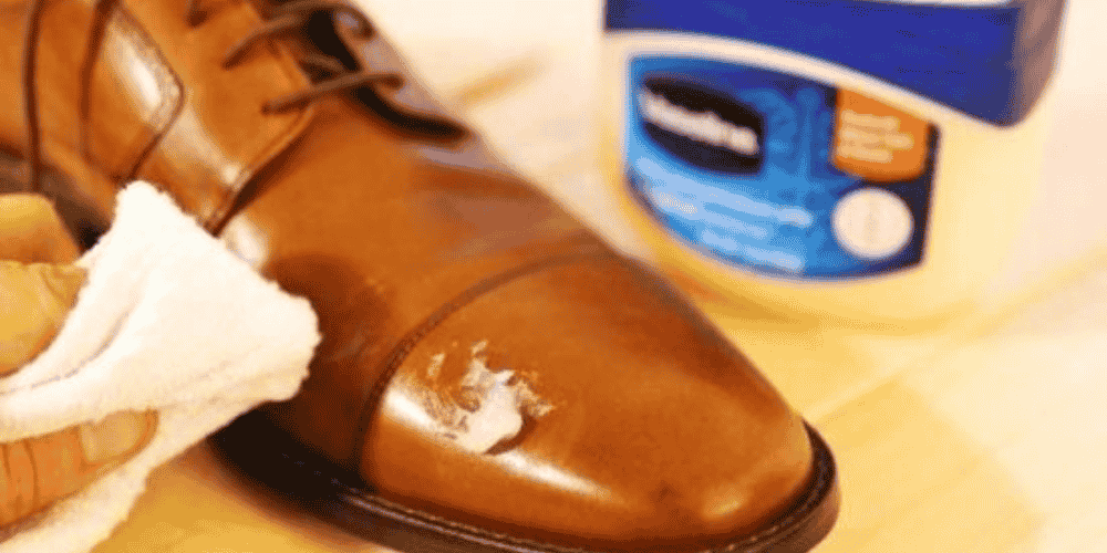applying Vaseline on leather shoe with cloth