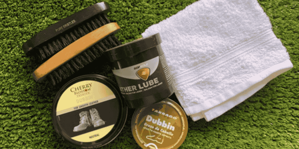 shoe dubbin, polish and cloth on green carpet